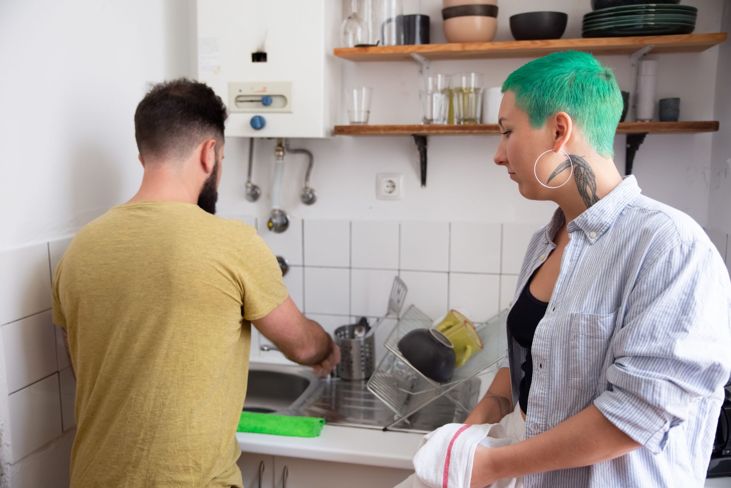 A couple sharing household chores together in a modern kitchen.