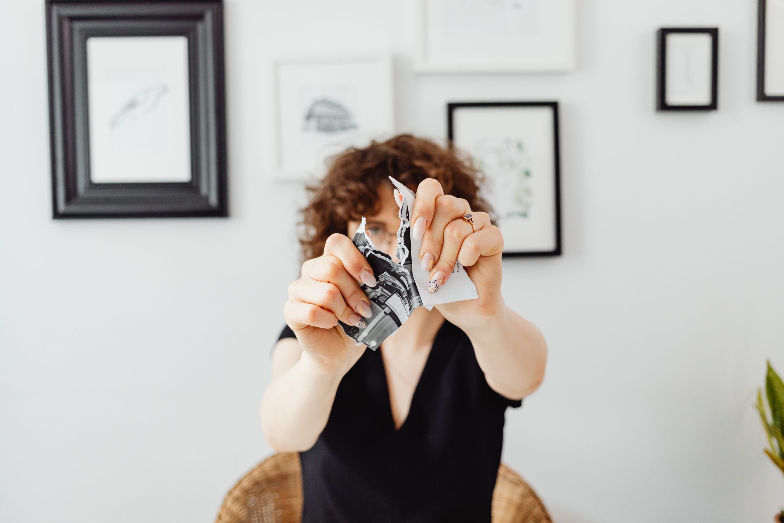 A woman tearing a sheet of paper in half.