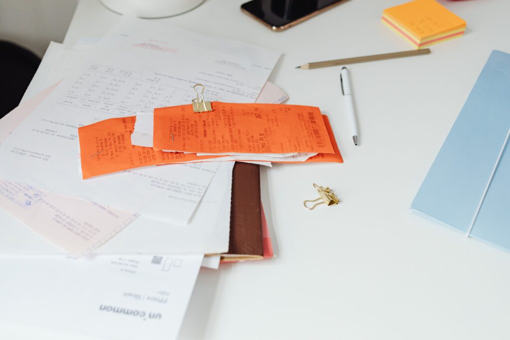 A tidy desk with receipts, documents and office stationery arranged for organization.