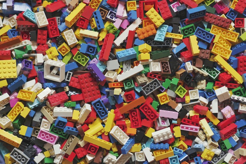 Parent and child sorting toys together into wooden bins and donation boxes